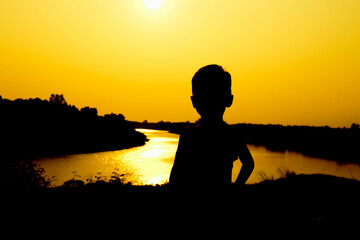 Silhouette of a family comprising a father, mother and two children happy family the sunset.Concept of friendly 