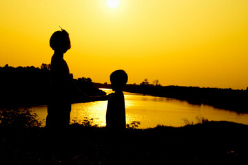 Silhouette of a family comprising a father, mother and two children happy family the sunset.Concept of friendly  - 646230135