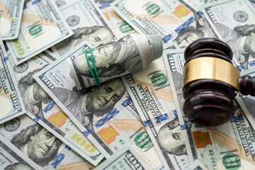 Gavel above piles of new 100 dollars bills as finance background.  Justice concept