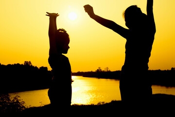 Silhouette of a family comprising a father, mother and two children happy family the sunset.Concept of friendly  - 646230188