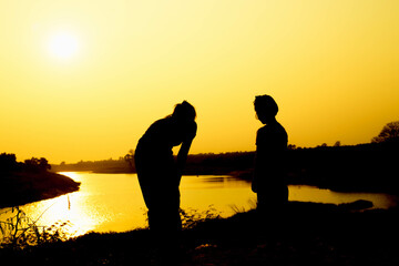 Silhouette of a family comprising a father, mother and two children happy family the sunset.Concept of friendly  - 646230385