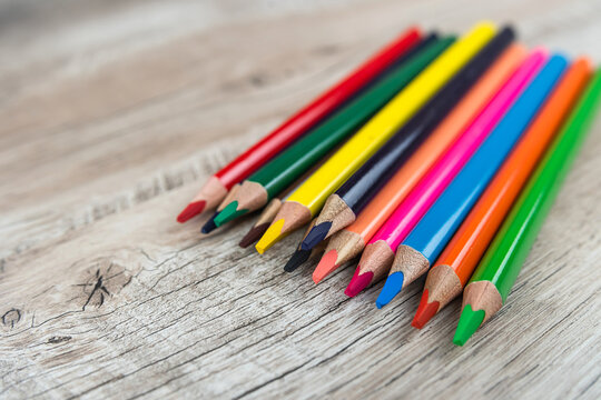 different color pencils for art or school at wooden table