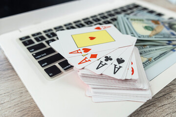 online gambling concept with laptop. Poker play card with dollar bills