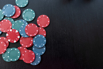 Colorful different value poker chips on black casino table, win after game