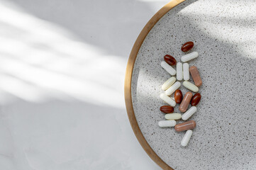 Medical treatment concept. Capsules, pills or drugs on plate on white background with natural...