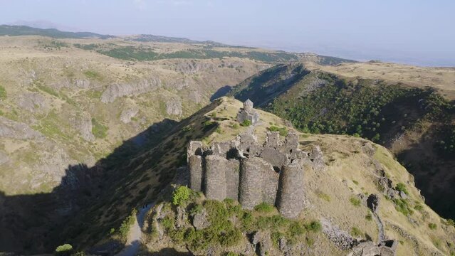 Forward reveal aerial shot of Amberd fortress on sunny summer day. Aragatsotn Province, Armenia.