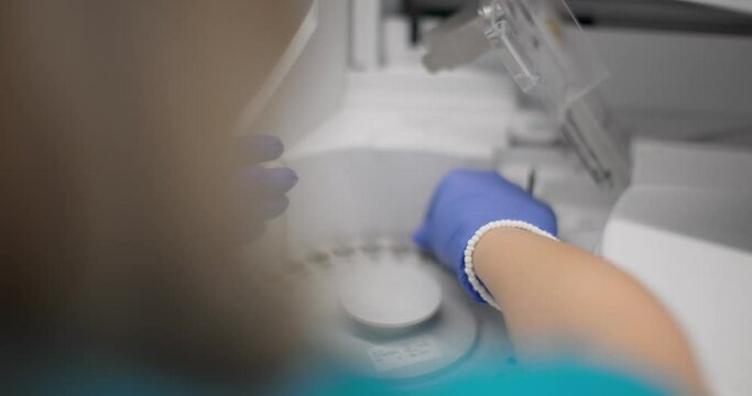 Clinician inserting urine sample in a medical centrifuge