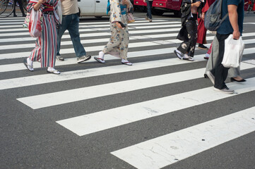 Cropped photo of Asian tourist walking on zebra cross in Asakusa district, Tokyo, Japan.