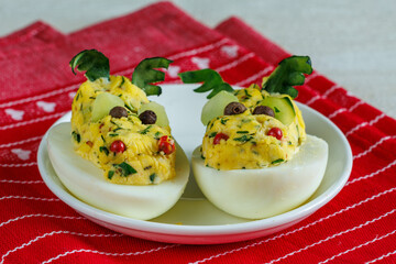 Stuffed eggs looks like dragon head on red napkin funny idea for party food. Halloween food. Chineese New year dish. Easter meal