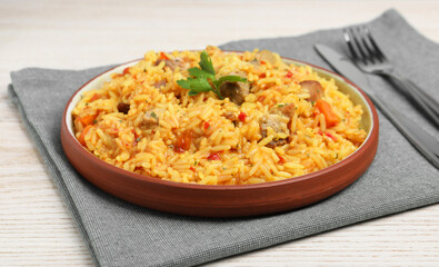 Delicious pilaf with meat served on white wooden table, closeup