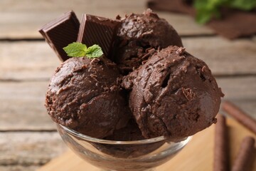 Tasty chocolate ice cream with mint in glass dessert bowl on table, closeup