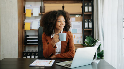 Obraz premium African Woman freelancer is working her job on computer tablet and laptop Doing accounting analysis report real estate investment data, Financial