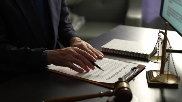 Young lawyer or legal advisor is reading and carefully checking the validity of documents and investment agreements for signing contracts managing justice concepts.