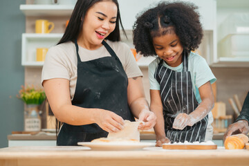 Kind African american parents teaching their adorable daughter how to cook healthy food, free space of kitchen, Happy black people family preparing healthy food in kitchen together