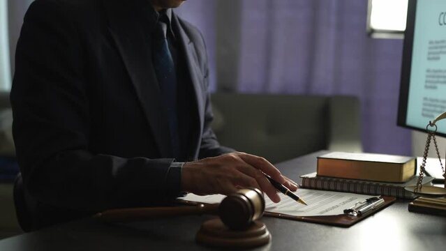 Young lawyer or legal advisor is reading and carefully checking the validity of documents and investment agreements for signing contracts managing justice concepts.