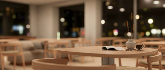Close-up image of a wooden round table in a cozy minimalist coffee shop or co-working space at night