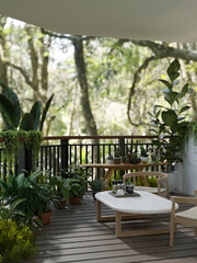 A beautiful greenery outdoor home balcony relaxation area with tropical plants.