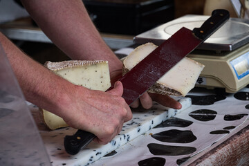 Cutting cheese at a street market in the French city of Dax