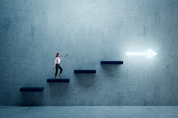 Side view of young businesswoman climbing illuminated arrow stairs to success on concrete wall background in interior. Financial growth, career development and forward concept.
