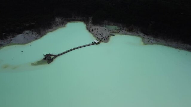 Aerial View of the Acidic Lake of Kawah Putih with Tourists Visiting Below in West Java, Indonesia.
