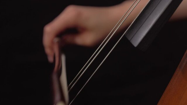 close up of woman playing cello with bow