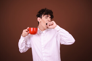 Funny student posing on a brown background early in the morning.