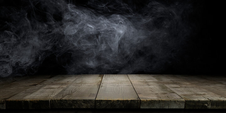 Wood table and smoke on dark background.