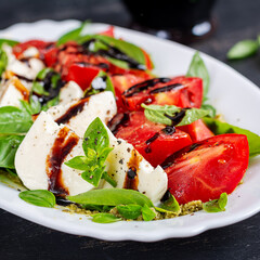 Caprese salad tomato for concept design. Dark background, close up. Food concept.