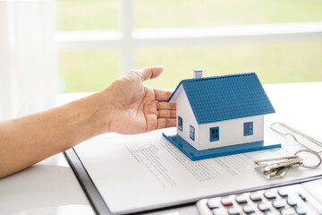 House model with real estate agent and customer discussing for contract to buy house, insurance or loan real estate background.