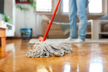 Person is washing parquet floor with mop, close-up. Bottom view. Cleaning service