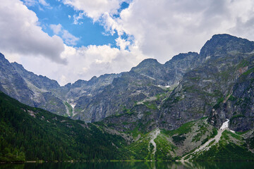 Amazing view on mountains range near beautiful lake at summer day. Tatra National Park in Poland. Panoramic view on Morskie Oko or Sea Eye lake in Five lakes valley