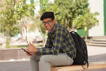 Obraz premium Young Indian middle class young man sitting at public place