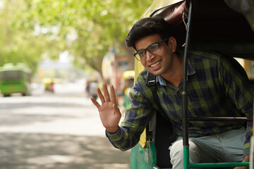 Young Indian middle class young man sitting in auto rickshaw