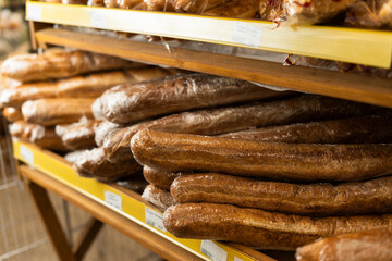 Freshly baked loaves of bread on shelves in supermarket or store
