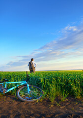 businessman rides a bicycle through a green grass field, the concept of activity, leisure or...