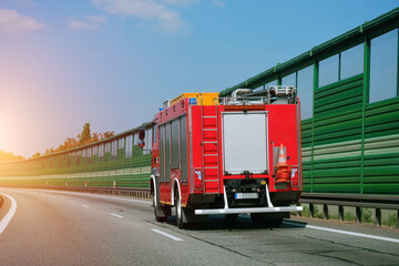 Firefighting rescue vehicle auto machine on a motorway highway driving in the right lane. First...