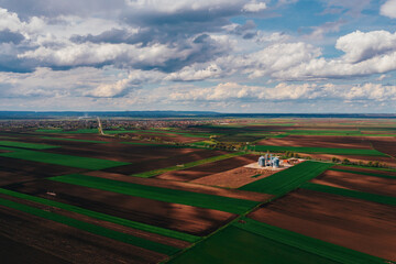 Farm silos in field, aerial view from drone pov on sunny spring day