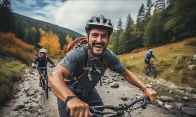 Rolgordijnen Young man smiles into the camera as he rides up extreme mountain bike. © Mangsaab