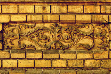 Vintage facade decoration made of concrete molding on rustic brick wall