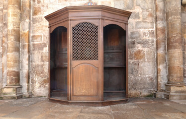 Confessional Box or Booth, a wooden cabinet or stall where the Priest presides over confession