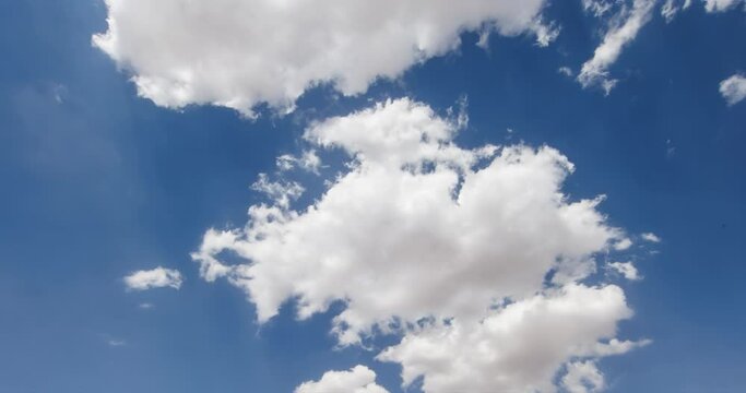 Formation and scattering of clouds in the blue sky timelapse. The cloud gradually first decreases in size and then increases again. Puffy fluffy white clouds. Cumulus cloud scape timelapse.