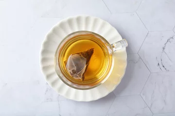Schilderijen op glas premium hot brew organic chinese green western black tea leaf bag hand pour in whisky glass pot and cup on luxury white marble table halal food beverage cafe drink menu design © perfectloop