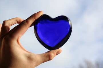 joli coeur bleu en verre transparent dans la lumière du jour