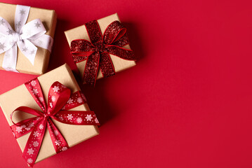 Christmas gift boxes with red balls on red background.