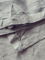Fototapeta premium The texture of natural linen fabric. Linen textile background, top view. Rough crumpled burlap. Napkin made of natural linen.