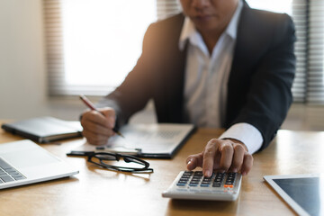 Close up view of hands of businessman use calculator calculate financial of business.