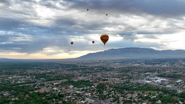 Albuquerque, New Mexico hot air balloon festival. Aerial shot of many hot air balloons flying high over scenic Alburquerque with views of city and mountains.