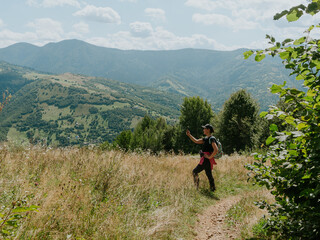 Traveler hiker millennial woman with smartphone backpack in Carpathian mountains summit Ukraine, Europe Girl backpacker taking picture of scenic landscape Active Lifestyle Solo Travel extreme activity