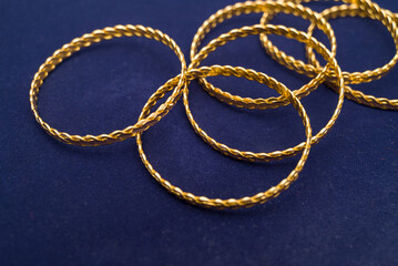 24k (24 carat) Turkish gold twist bracelet standing in a heap on a dark blue background in the gold store