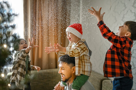 Father and sons playing with fake snow at home